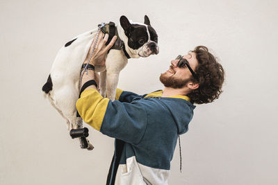 Man with dog against wall