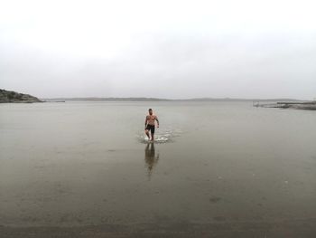 Full length of man on beach against sky