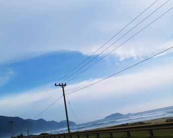 Low angle view of electricity pylon against sky