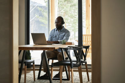 Businessman using laptop on dining table at home