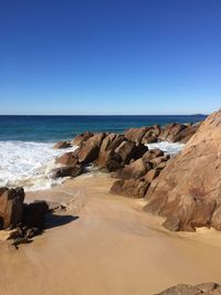 Scenic view of beach against clear blue sky