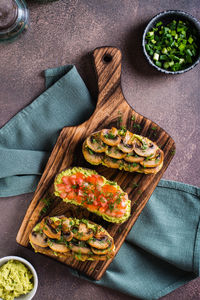 Sandwiches on rye bread with guacamole, fried mushrooms, tomatoes and dill top and vertical view