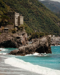 Scenic view of sea by buildings against mountain