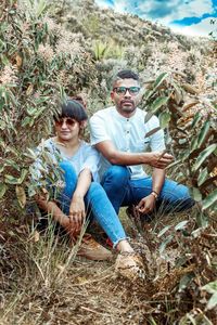 Portrait of smiling young woman sitting on plant