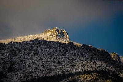 Low angle view of rock on mountain against sky