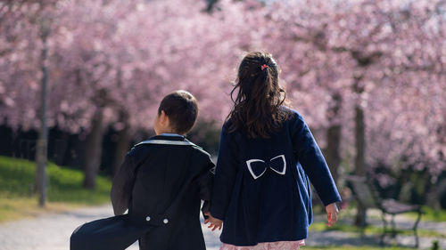 Rear view of couple on flower against trees