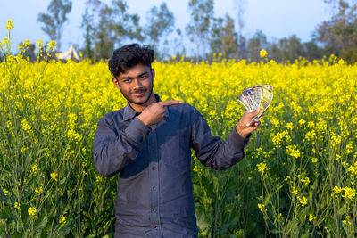 Portrait of young man standing in field