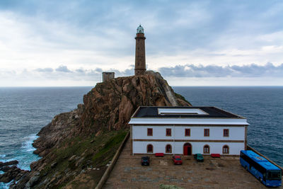 Lighthouse in sea against sky