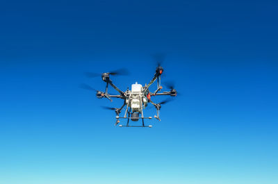 Agricultural drone in flight on a background of blue sky. field spraying new technologies.