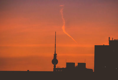 Silhouette buildings against orange sky