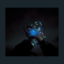 Close-up of hand holding illuminated light against black background