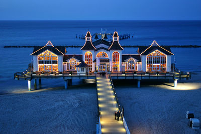 Building by sea against blue sky