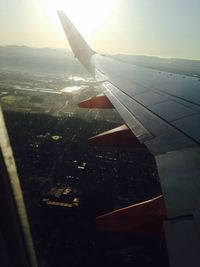 Cropped image of airplane wing over landscape