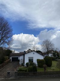 Houses and trees on field against sky