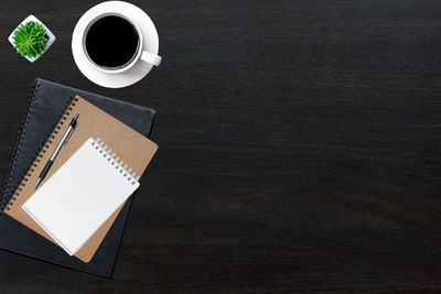 High angle view of coffee cup and office supplies with smart phone on table