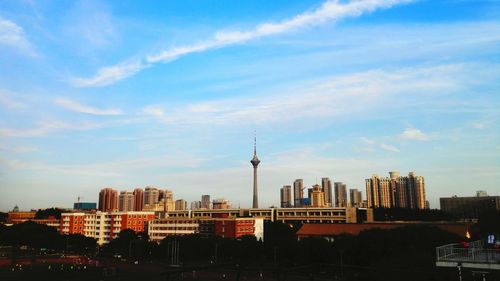 View of cityscape against cloudy sky