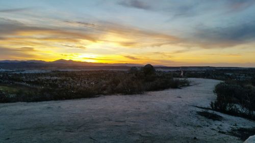 Scenic view of landscape against sky at sunset