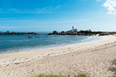 Scenic view of beach with the lighthouse of pontuvel, finistere, brittany, france