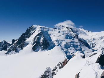 Snow covered mountain against blue sky