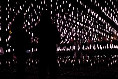 Silhouette people standing at illuminated night