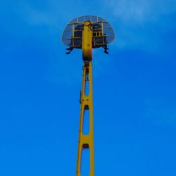 Low angle view of ferris wheel against blue sky