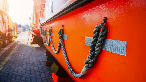 Close-up of fire hydrant on footpath against orange wall