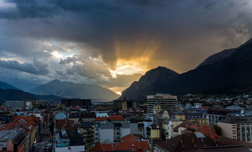 Townscape by mountains against sky during sunset