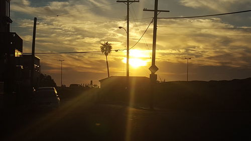 Cars on road against sky during sunset