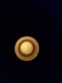 Close-up of illuminated light bulb against black background