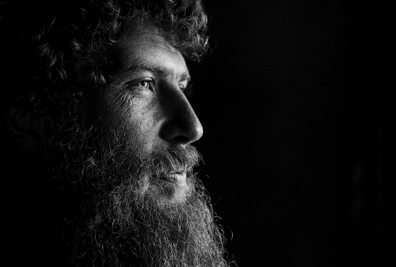 headshot, lifestyles, close-up, black background, studio shot, indoors, young adult, human face, person, front view, contemplation, serious, leisure activity, looking at camera, portrait, head and shoulders, young men