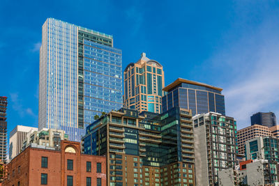 Low angle view of modern buildings against blue sky