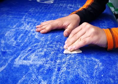 Close-up of woman hand on blue table