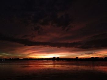 Scenic view of sea against dramatic sky during sunset