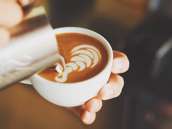 Close-up of hand holding coffee cup