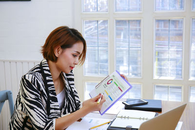 Woman looking away while using mobile phone