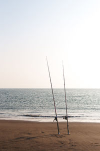 View of calm beach against clear sky