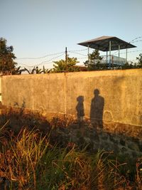 Shadow of man on field against clear sky