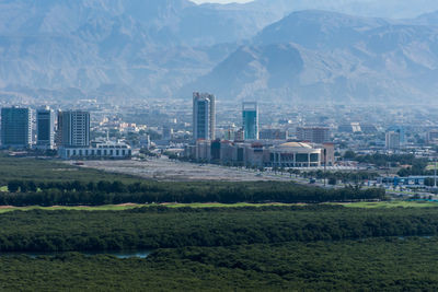 Scenic view of field by buildings against sky