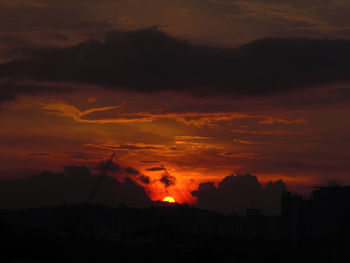 Silhouette landscape against orange sky