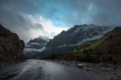 Scenic view of road by mountains against sky