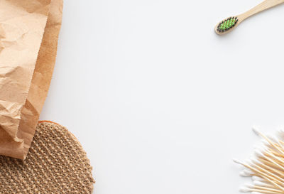 Ecological concept. toothbrush, wooden cotton swabs, craft bag and natural washcloth on white 