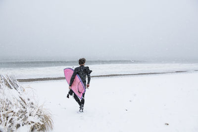 Man going surfing during winter snow