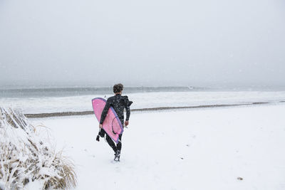 Rear view of person on snow covered land