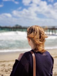 Rear view of woman looking at sea against sky