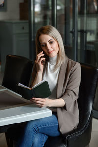 Smiling businesswoman talking on phone at office