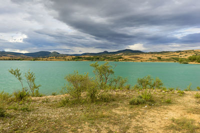 Scenic view of lake against cloudy sky