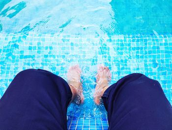 Low section of man sitting in swimming pool