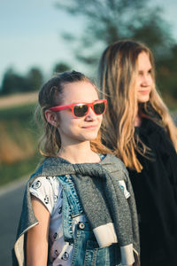 Portrait of smiling young woman wearing sunglasses standing outdoors