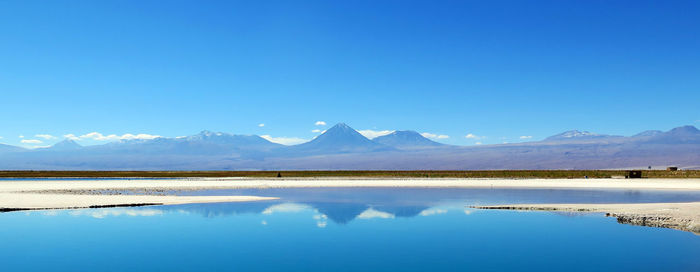 Scenic panoramic view of sea and mountains against clear blue sky