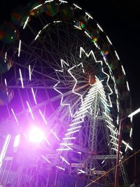 Low angle view of ferris wheel at night